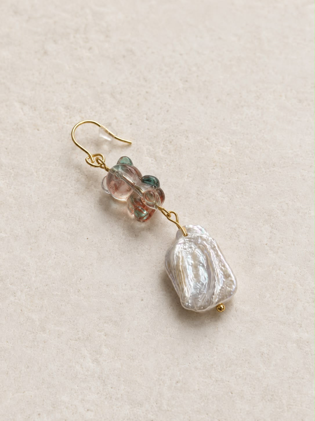 Pendiente Barroca Dulce individual hecho a mano con osito de cristal en tonos rosados y verdes, perla barroca y cierre dorado.