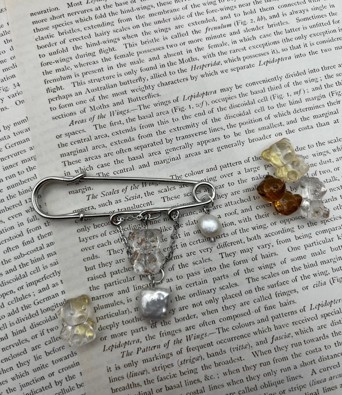 Broche Barroca Dulce – imperdible plateado con ositos de resina transparente, amarillo y marrón, cadena con ositos colgantes y perlas barrocas blancas de agua dulce, hecho a mano en Murcia