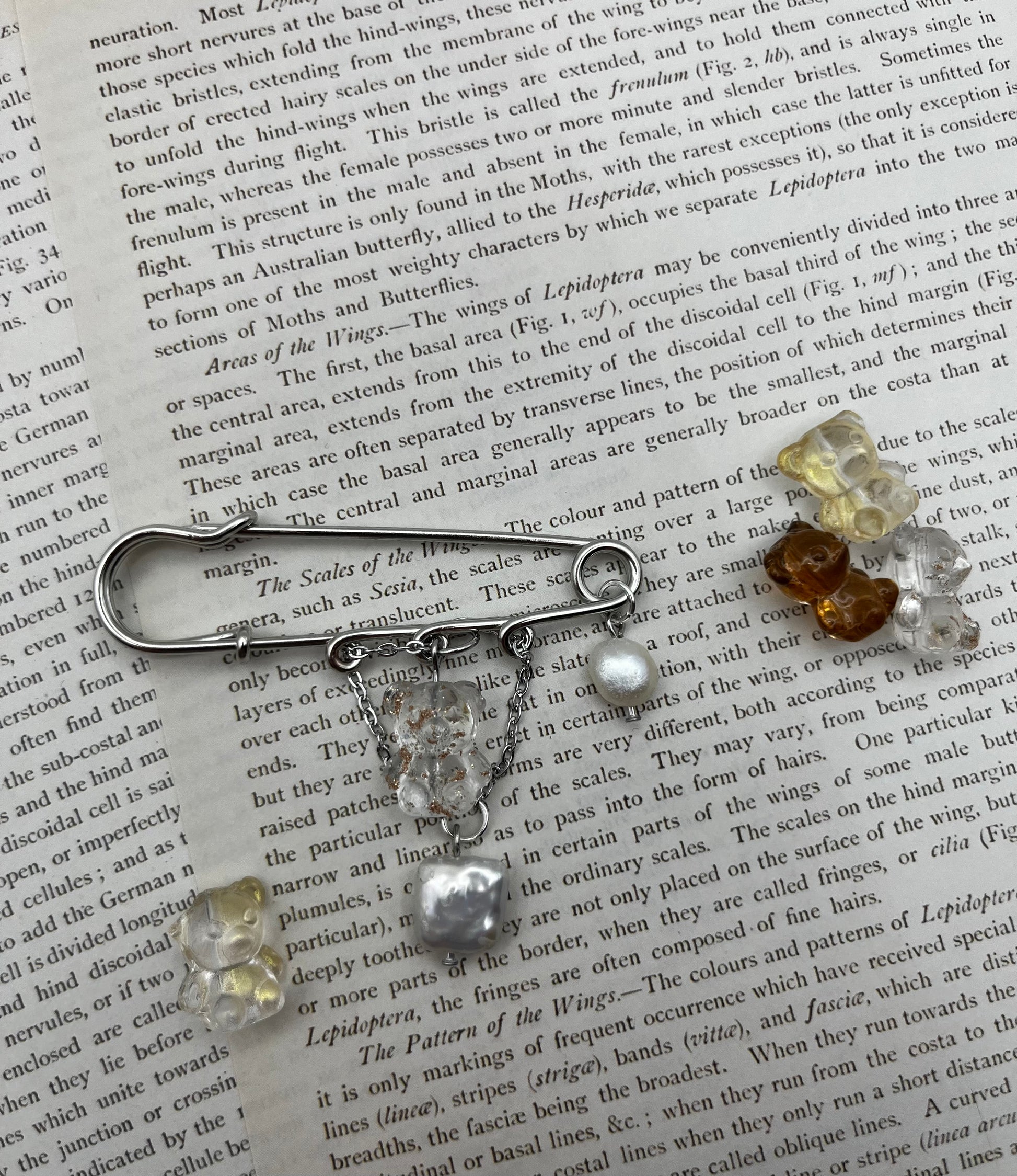Broche Barroca Dulce – imperdible plateado con ositos de resina transparente, amarillo y marrón, cadena con ositos colgantes y perlas barrocas blancas de agua dulce, hecho a mano en Murcia