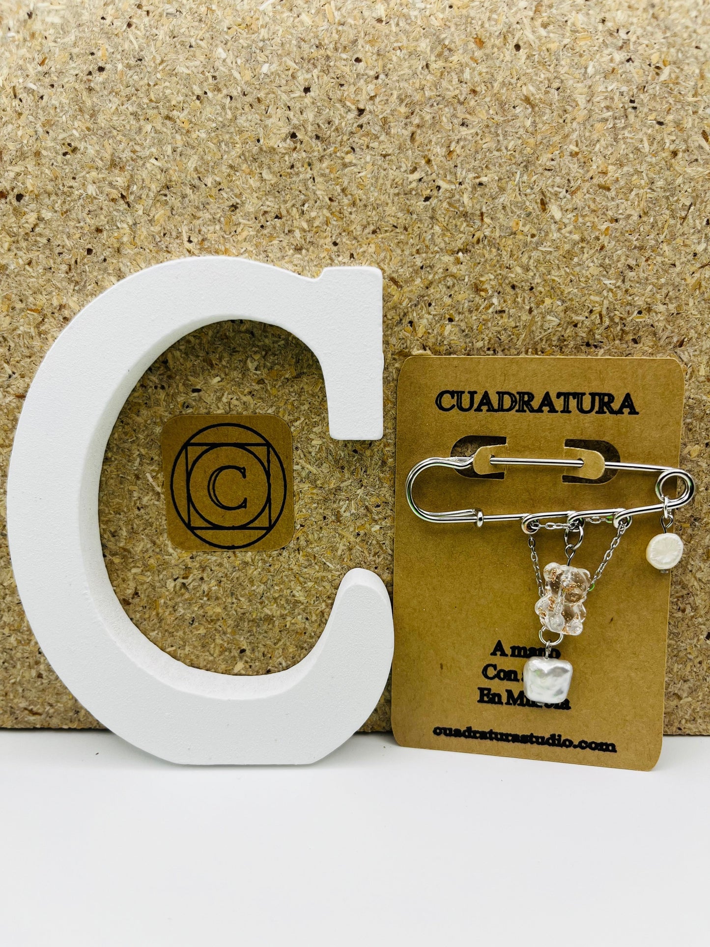 Broche Barroca Dulce – imperdible plateado con osito de resina transparente, corazón de nácar blanco y perla barroca blanca, presentado en tarjeta Cuadratura, hecho a mano en Murcia