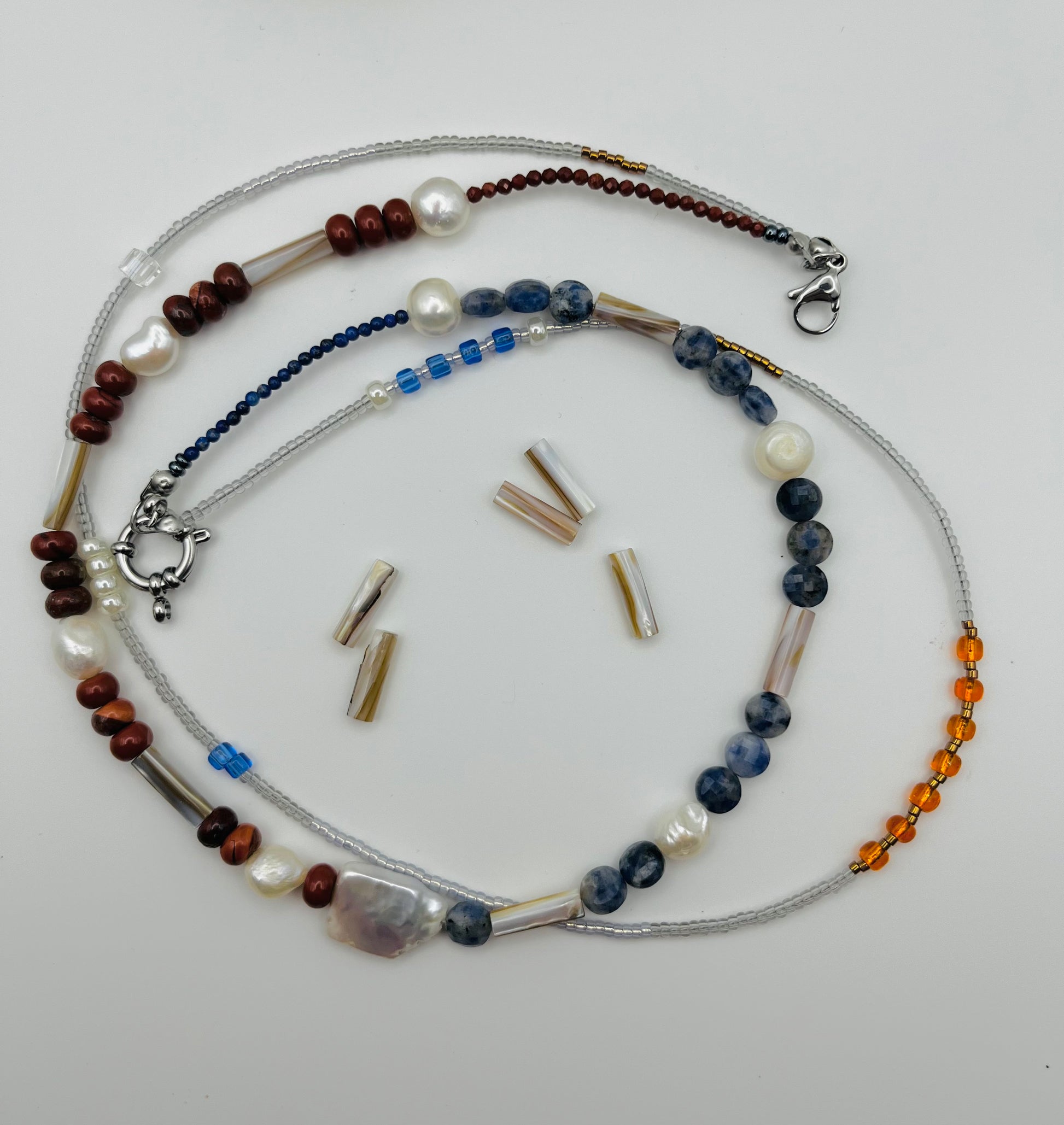Collar Bajamar – doble collar con jaspe rojo, lapislázuli azul facetado, perlas barrocas blancas, cuentas tubulares plateadas, semillas de rocalla transparentes, azules y ámbar naranja, con cuentas tubulares sueltas, hecho a mano en Murcia