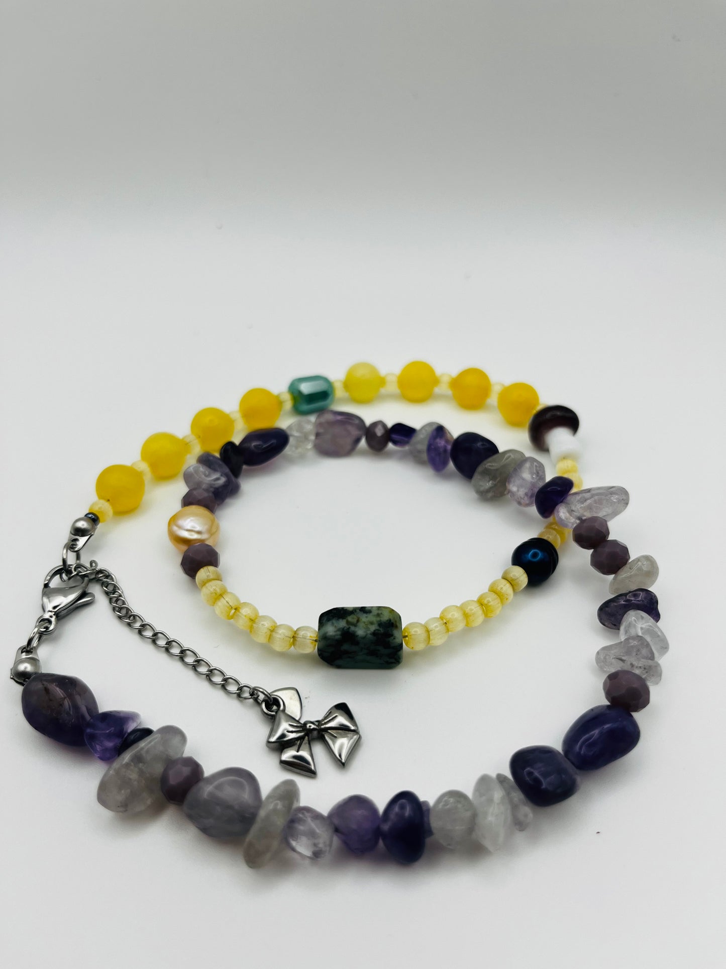 Collar Dalia – doble collar enrollado con jade amarillo, esmeralda verde, perla barroca amarilla, perla negra, chips de amatista morada y lila, cuarzo transparente y ahumado, semillas de rocalla amarillo pálido y cadena de extensión con charm de lazo plateado, hecho a mano en Murcia