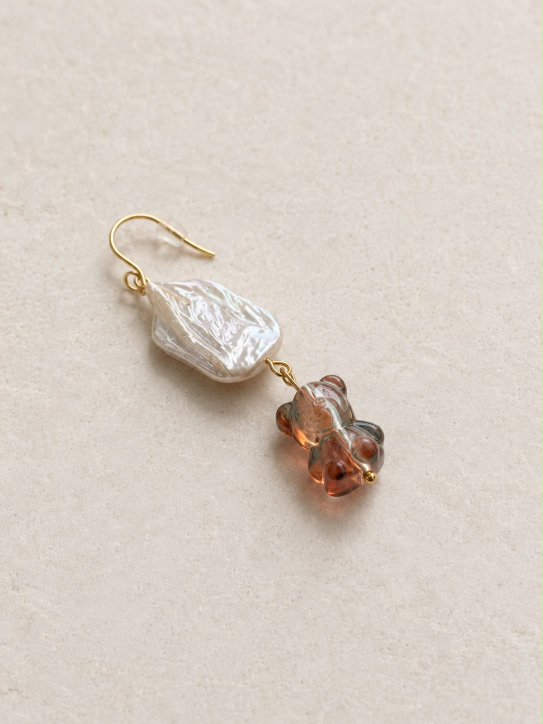 Pendiente Barroca Dulce individual hecho a mano con perla barroca, osito de cristal rosa y cierre dorado.