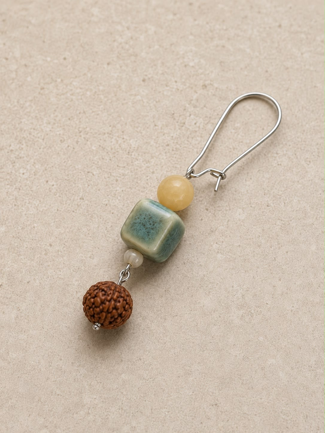 Pendiente Siena individual hecho a mano con cerámica artesanal verde, jade amarillo, cuenta de rudraksha y cierre plateado.