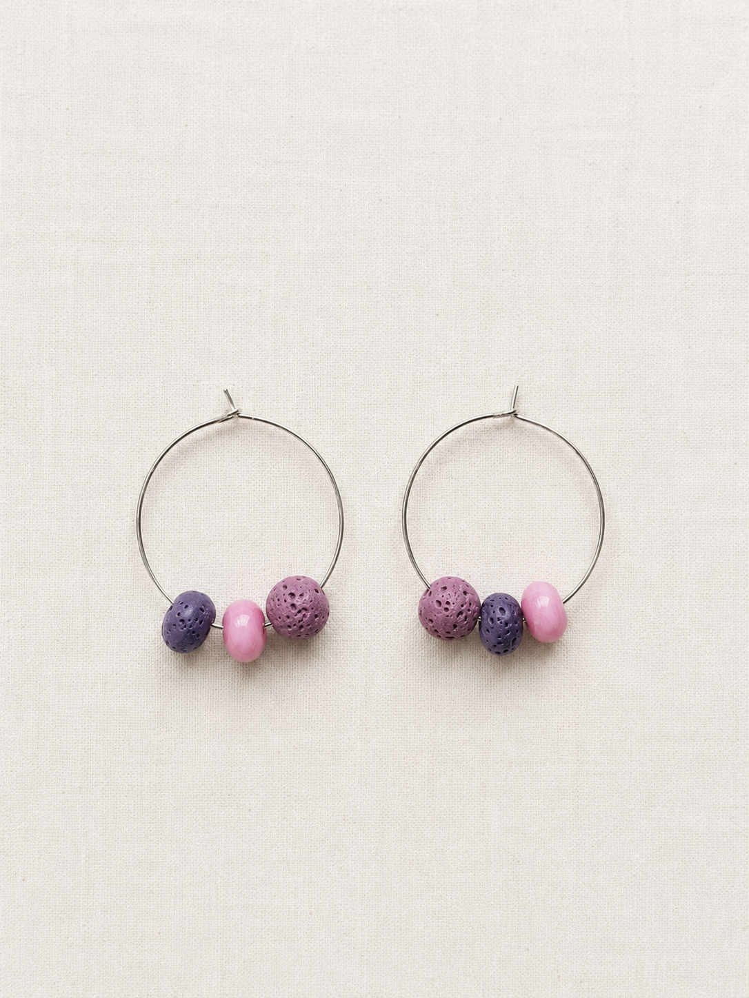 Pendientes Berry de aro en acero inoxidable con cuentas de piedra volcánica morada y cuentas de cristal rosa, hechos a mano.