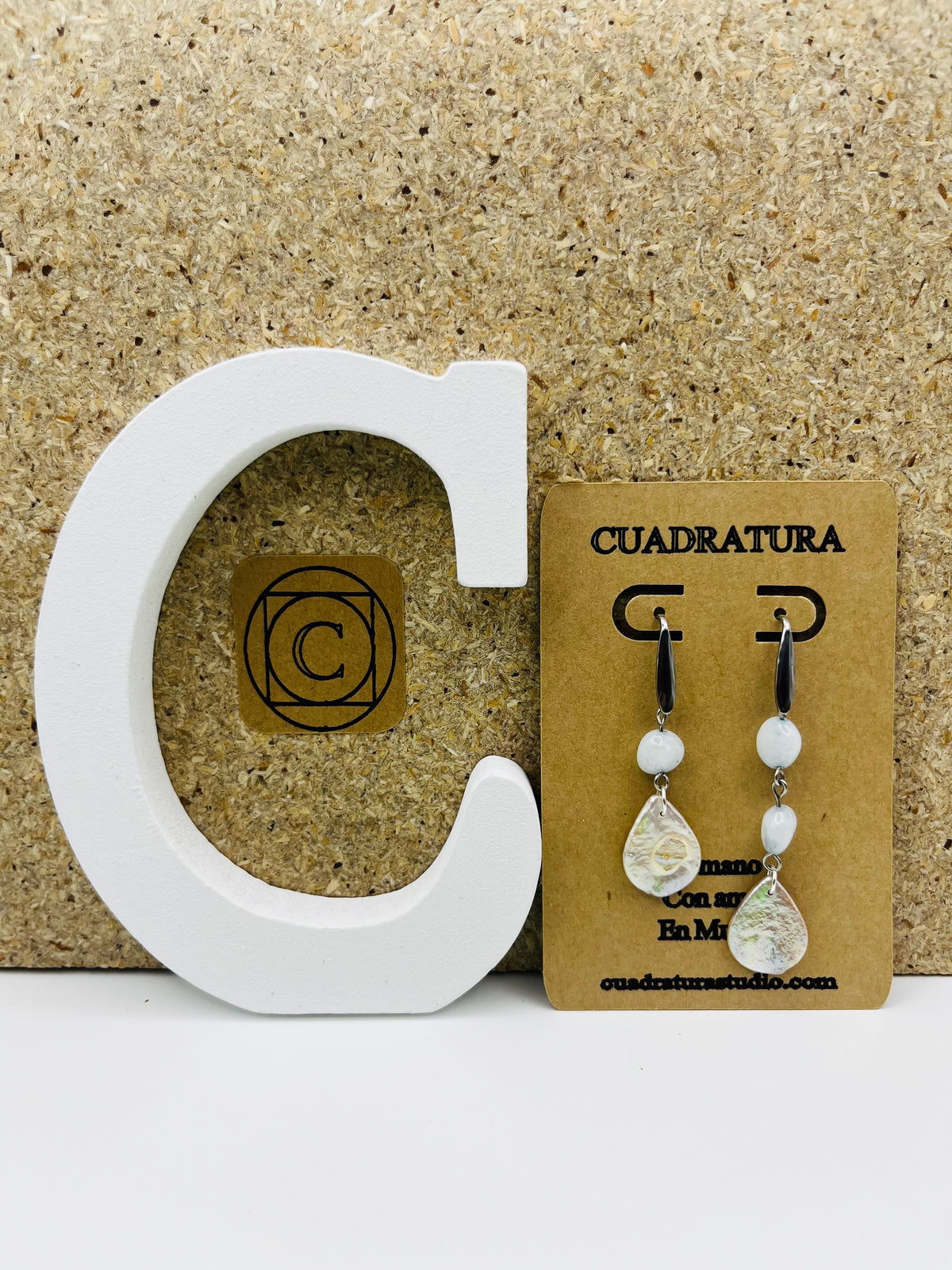 Pendientes artesanales con enganche negro, cuenta blanca y colgante gota de nácar, montados a mano en Murcia

