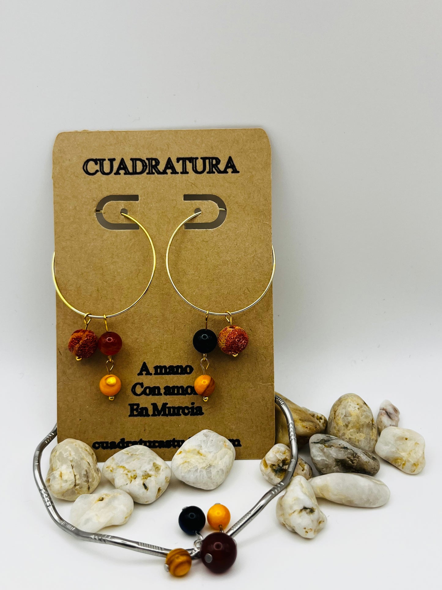 Conjunto artesanal Cala: pulsera aro plateado y pendientes aro dorado con lapislázuli, ágata roja y amarilla, presentados en tarjeta Cuadratura, montados a mano en Murcia
